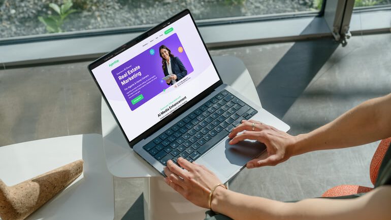AgentUp AI-powered real estate marketing platform displayed on a laptop for listing image enhancement and property marketing.