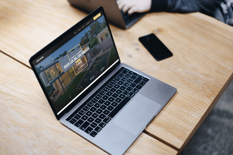 Laptop on a desk displaying a luxury single property website