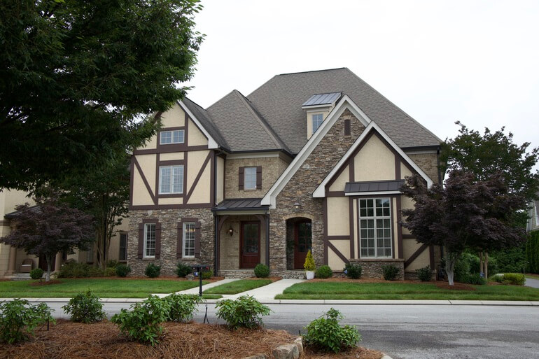 Before and after comparison of a house exterior demonstrating AI real estate photo editing.