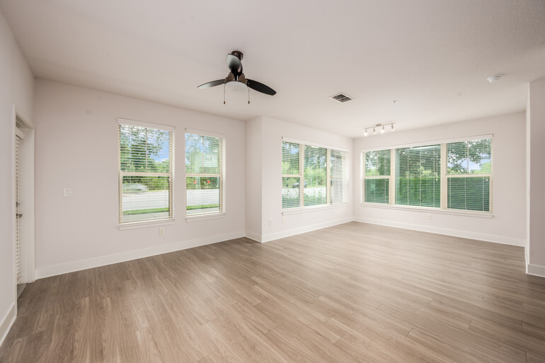 Side-by-side comparison of an empty living room and the same space AI virtually staged with furniture.