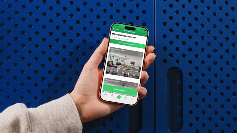 Hand holding a smartphone displaying the AgentUp AI virtual staging app for real estate.