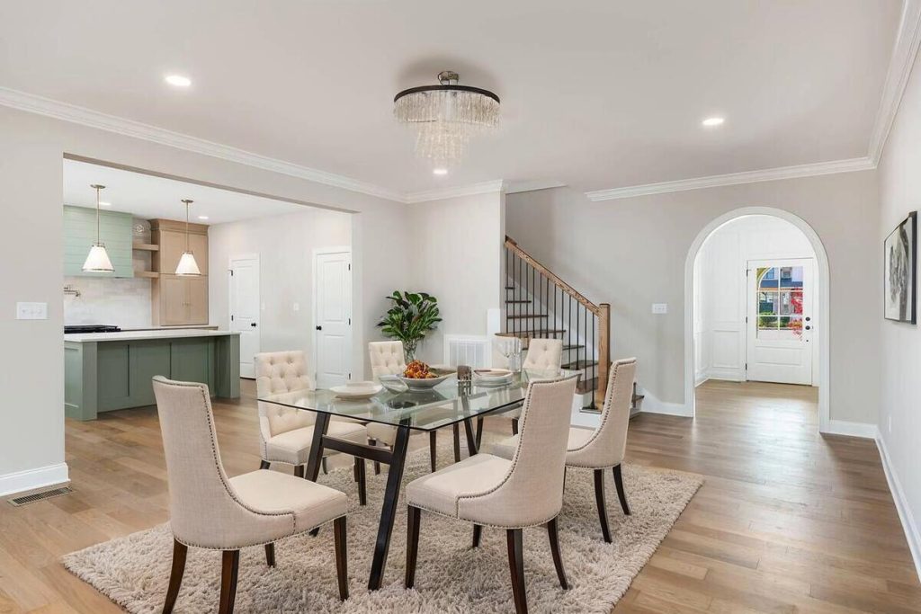 Elegant dining room featuring a glass table and upholstered chairs through virtual staging.