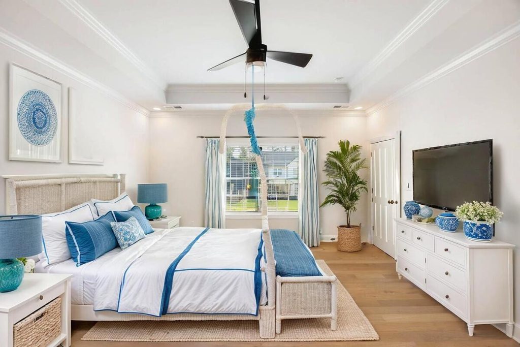 Luxury bedroom virtually staged with coastal-inspired furnishings and blue accents.