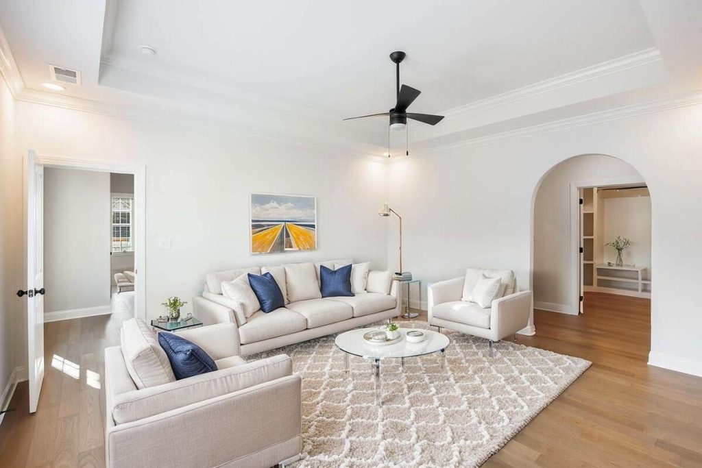 Bright living room staged with white furniture and modern décor.
