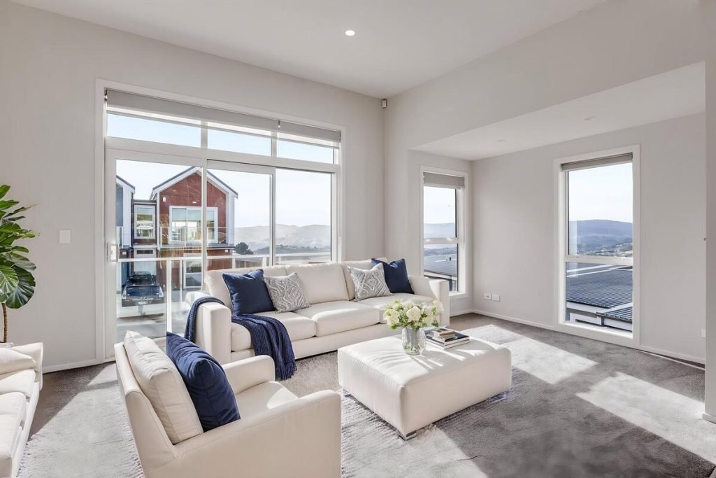 Best AI virtual staging example of a bright living room with a white sofa and navy accents.