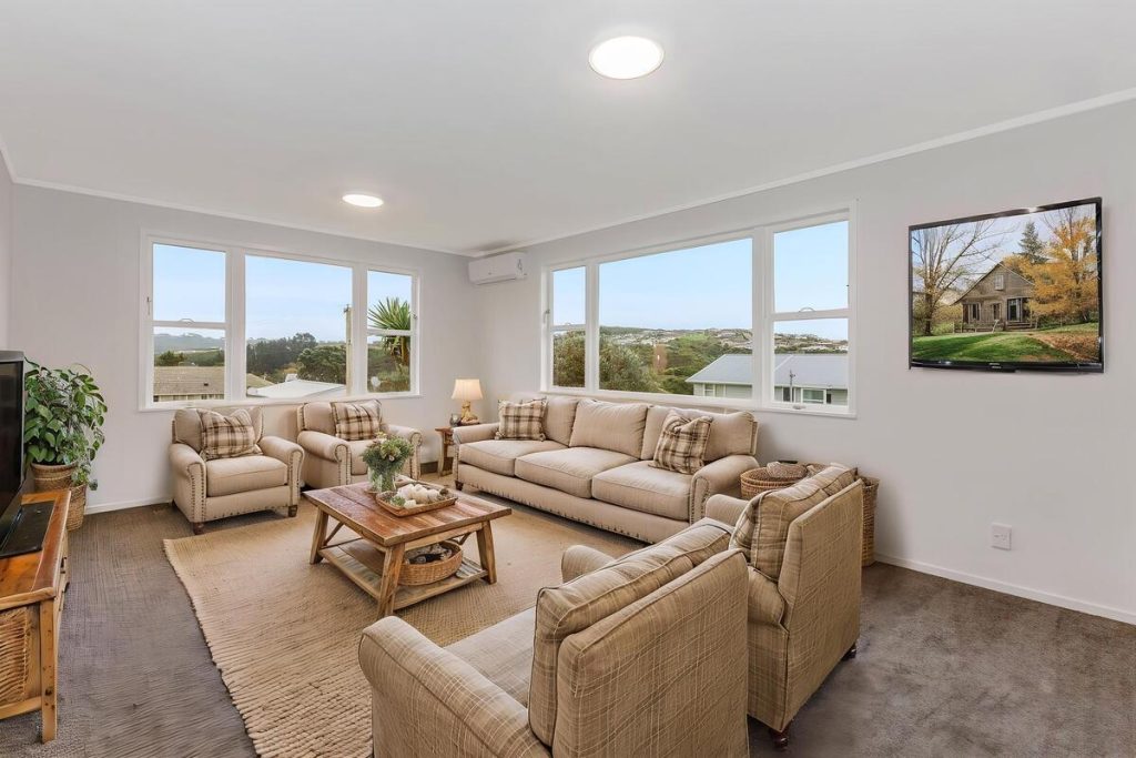Best AI virtual staging example of a spacious living room with neutral furnishings and wood accents.