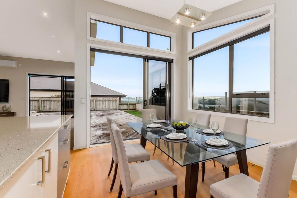 Best AI virtual staging example of a modern dining area with a glass table and neutral chairs.