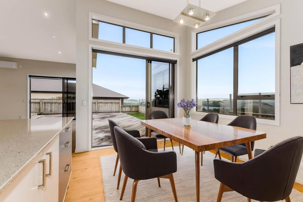Best AI virtual staging example of a dining area with a wooden table and dark chairs.
