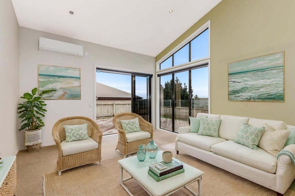 Best AI virtual staging example of a bright living room with white seating and coastal decor.