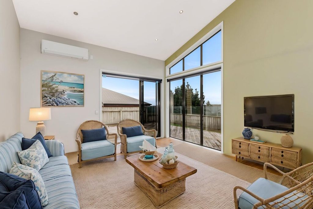 Best AI virtual staging example featuring wicker furniture and soft blue accents.
