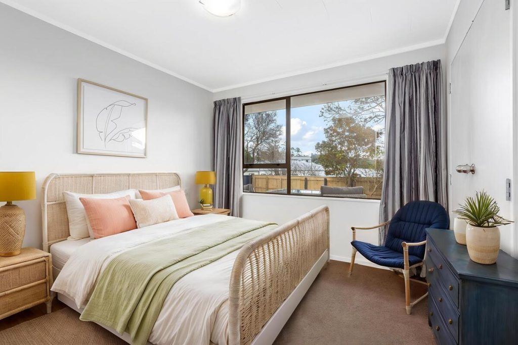 Best AI virtual staging example of a bedroom with rattan furniture and soft pastel accents.