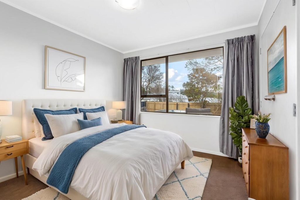 Best AI virtual staging example of a bright bedroom with blue accents and modern furniture.