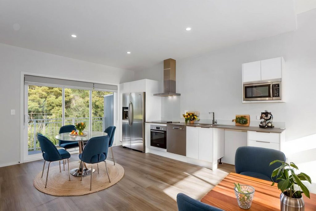 Best AI virtual staging example of a modern dining area with blue chairs and a round table.
