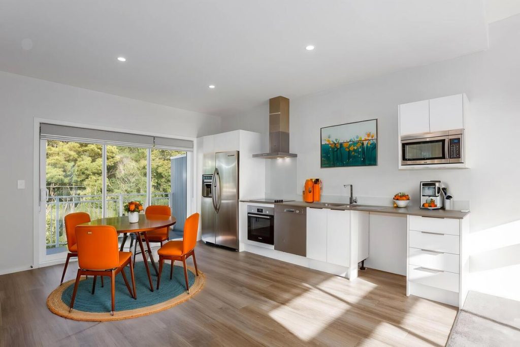 Best AI virtual staging example of a bright kitchen dining area with orange chairs.