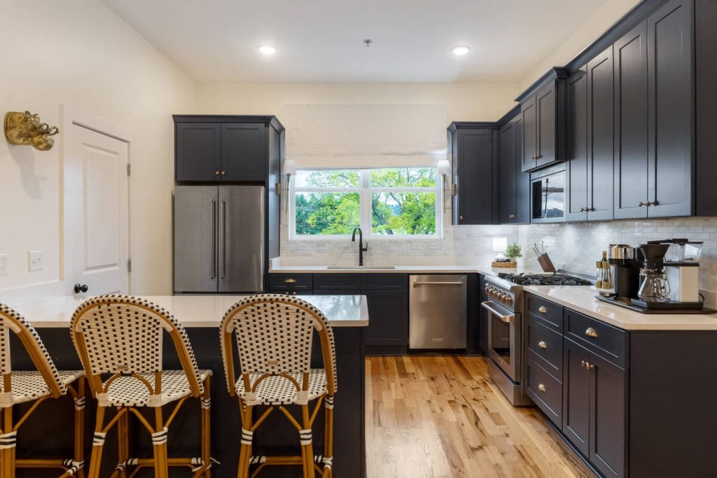 AI real estate photo editing showcasing a modern kitchen with dark cabinets and natural-looking colors.