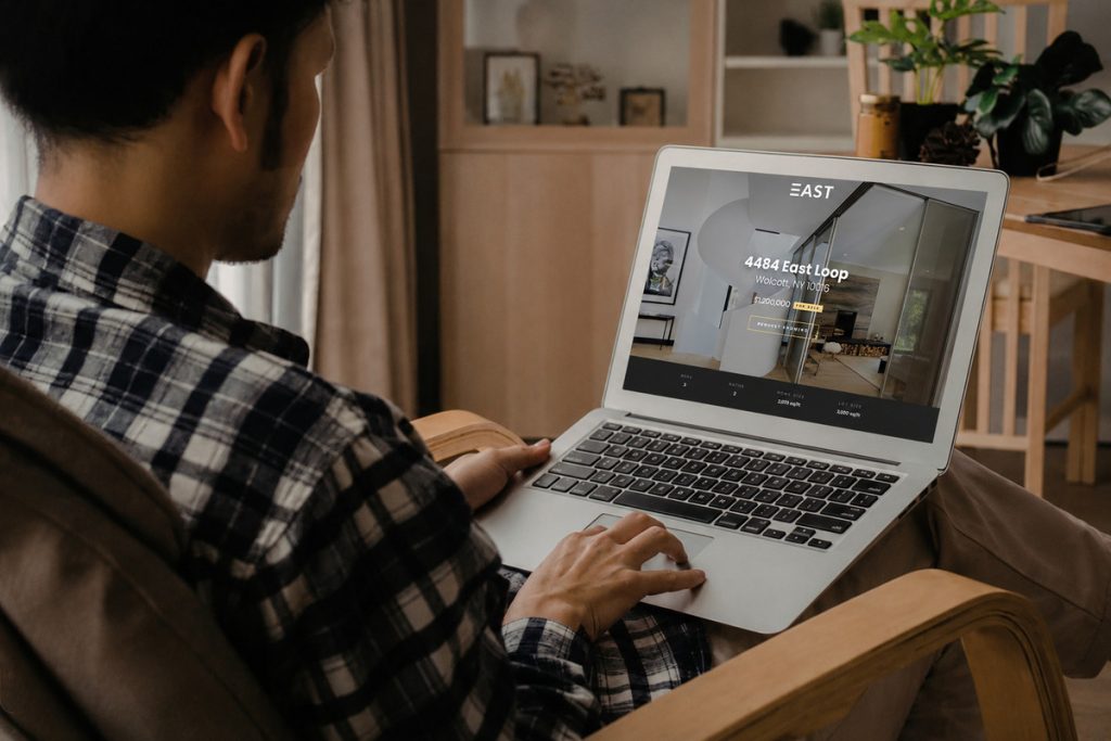 Person viewing a single property website template on a laptop