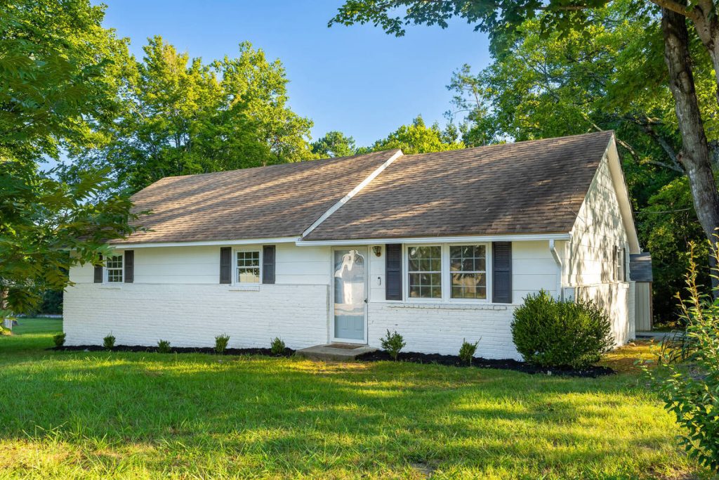 Real estate photo editor enhancing the lighting and color of a small home exterior