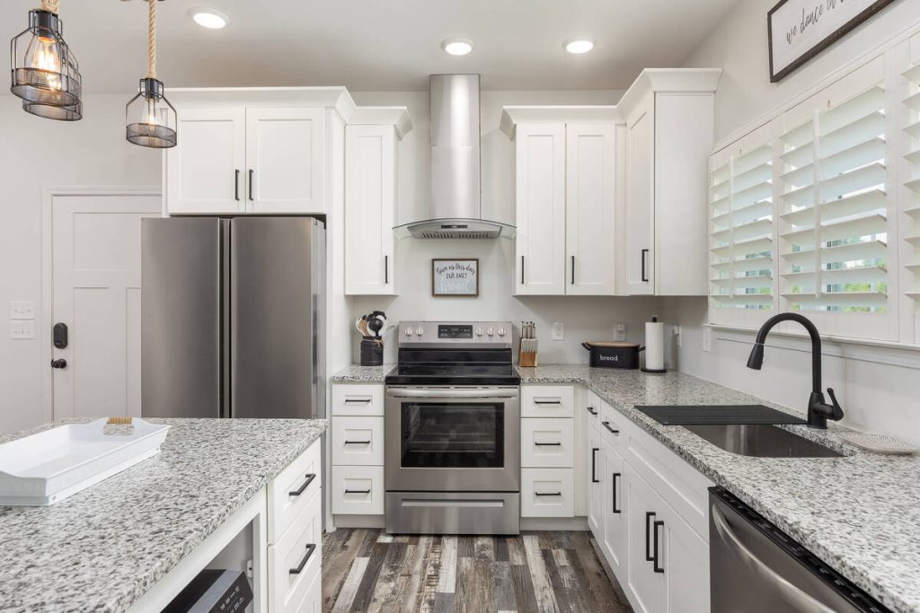 Real estate image editing showcasing a bright modern kitchen with white cabinetry