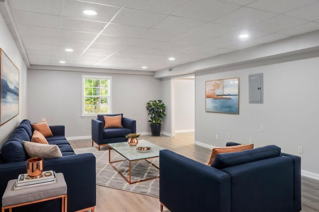 Real estate image editing showing a virtually staged living room with blue furniture