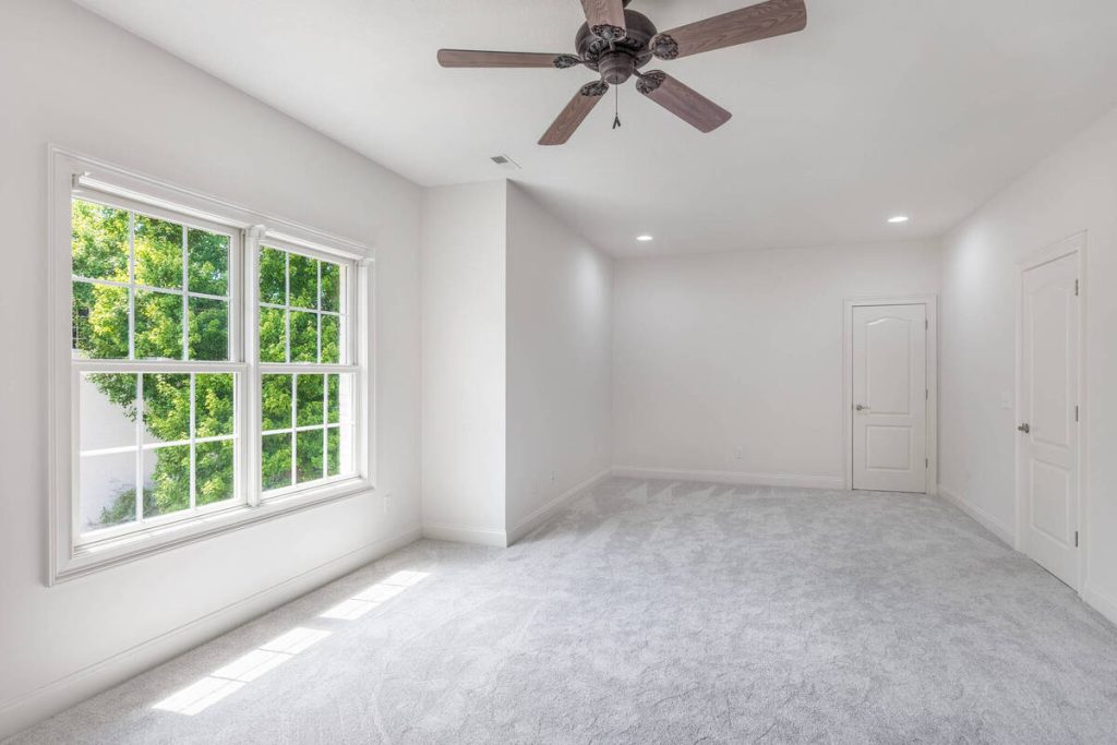 Large empty family room before furniture is added with virtual staging software.