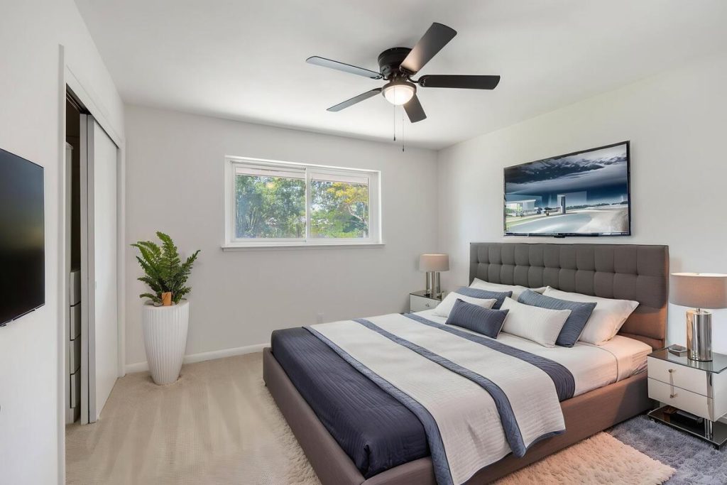 Modern bedroom with gray bed and decor created using virtual staging software.
