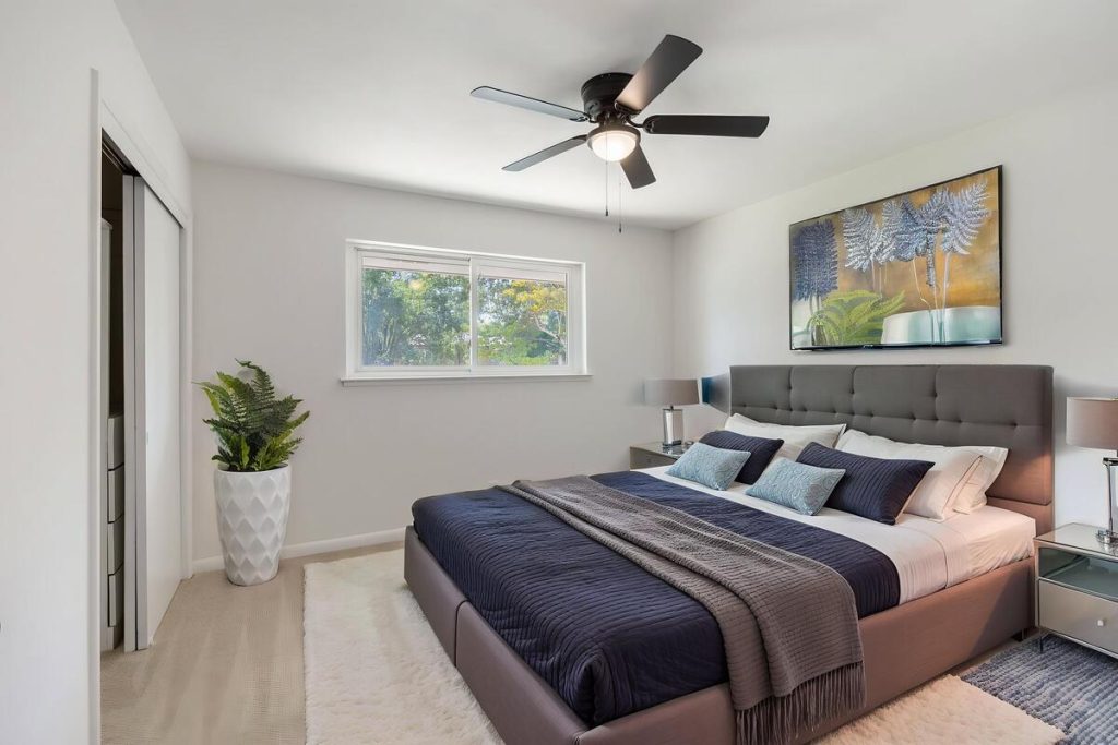 Contemporary bedroom design with coordinated bedding created using virtual staging software.